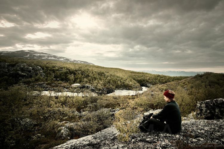 Woman hiker sitting on rock 