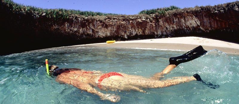 seorang turis sedang snorkling