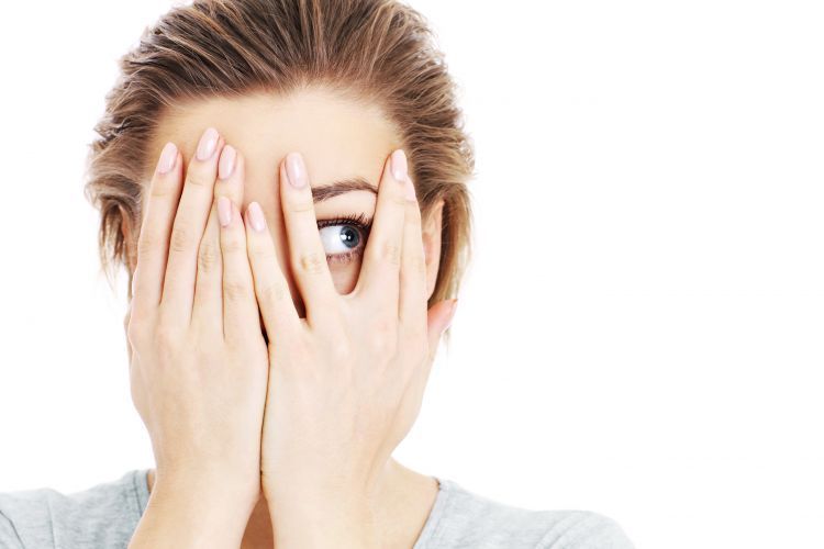 A picture of a scared woman covering her eyes over white backgro