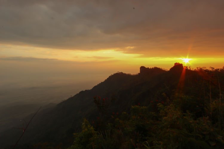 Sebermula cahaya dari timur di Puncak Suroloyo.