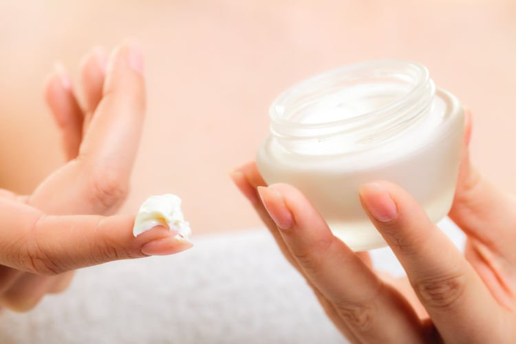 Skincare. Woman taking care of her dry complexion. Moisturizing cream in female hands isolated. Beauty treatment.