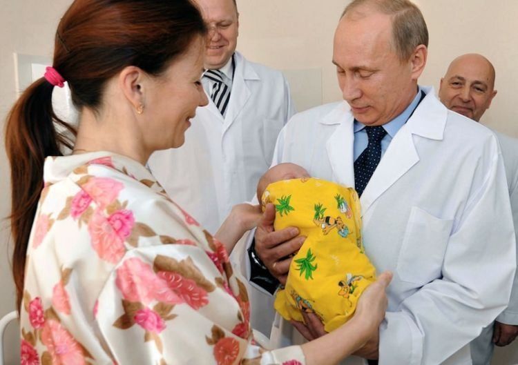 Russian Prime Minister Vladimir Putin, right, takes newborn baby Pyotr Nikolayev from his mother Yelena in a maternity hospital in Kaliningrad, Russia, Wednesday, Nov. 2, 2011. Baby boy Pyotr Nikolayev was born in the western Russian city of Kaliningrad on Monday, the day when the United Nations said a symbolic 7 billionth baby was born. (AP Photo/RIA Novosti, Alexei Nikolsky, Pool)