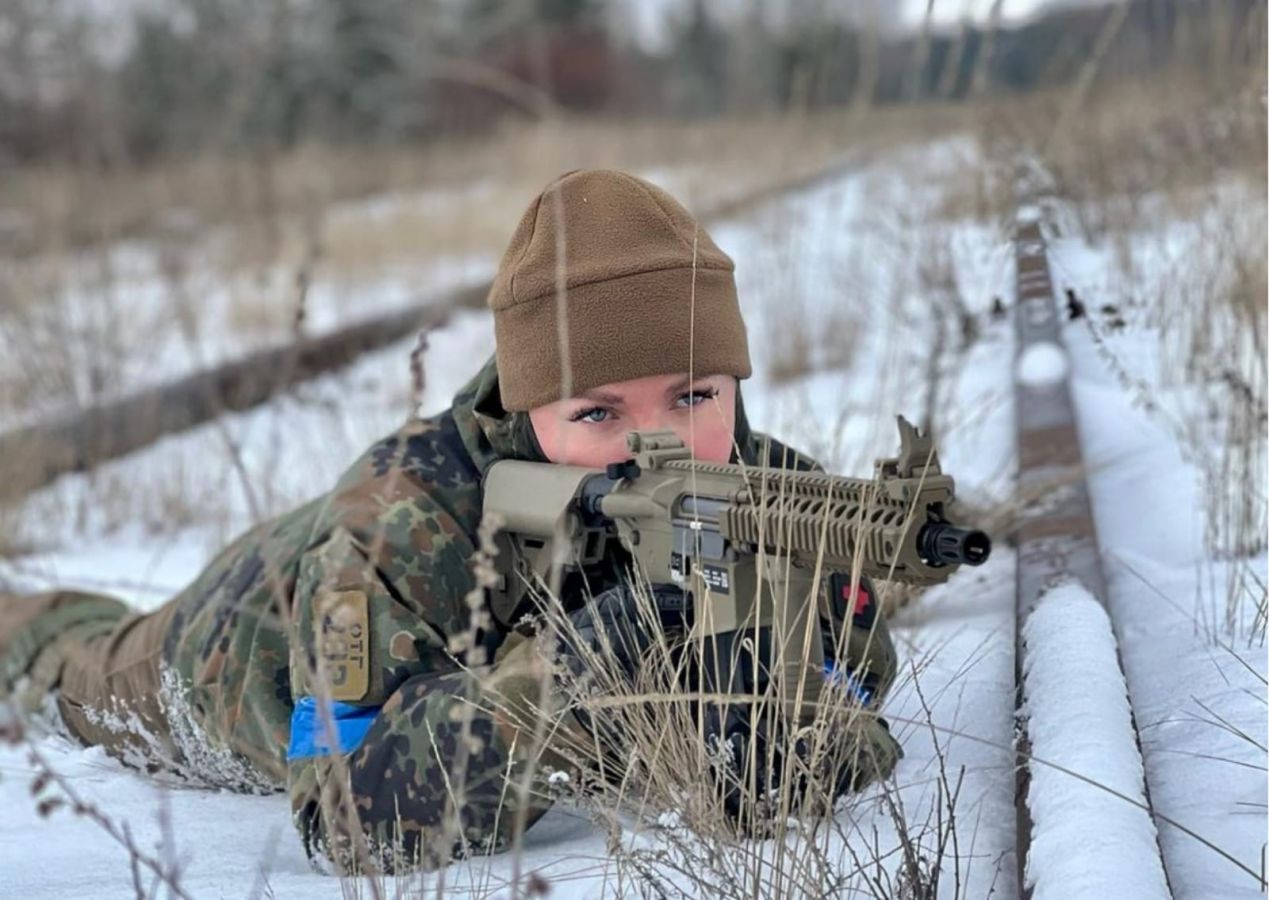 Anastasiia Lenna sedang membidik dengan airsoft gun