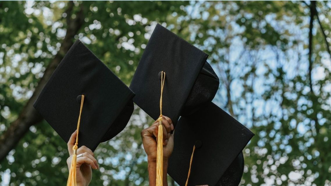 40 Ucapan Selamat Wisuda untuk Sahabat dan Pacar yang Paling Relate & Nggak Pasaran 8 Wisudawan mengangkat topi toga ke udara di luar ruangan